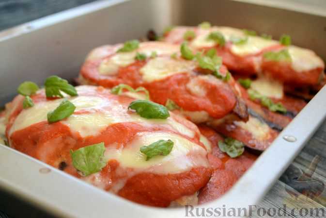 Подача готовой запеченной курицы с томатами и зеленью